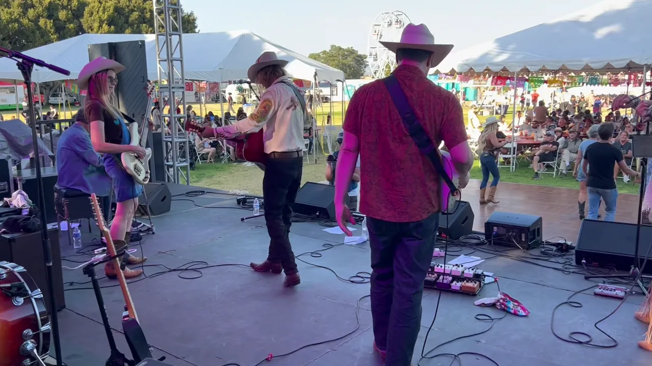 Country band performing on the Camarillo Fiesta stage with the festival audience visible beyond the monitors